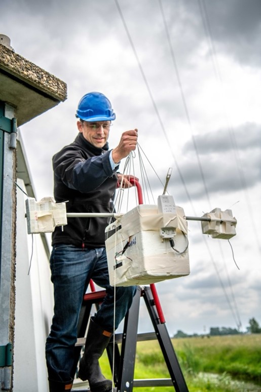 A sonde team member holding a multi-rigged sonde payload with a radiosonde, dual NO2 sondes and an ozone sonde, after calibration, just before launch. Picture credit: Arnoud Apituley